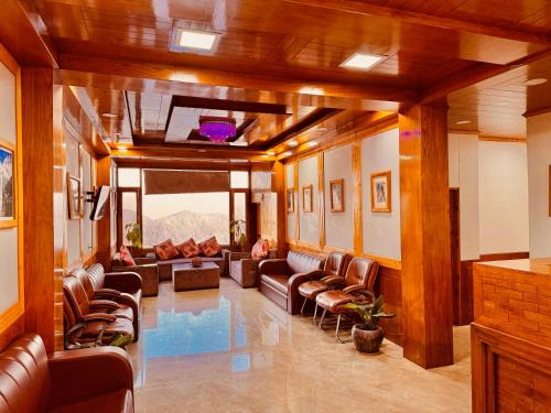 a living room with leather couches and chairs at Nature Valley View Resort KOTI - on Chail Road with Parking in Kūfrī