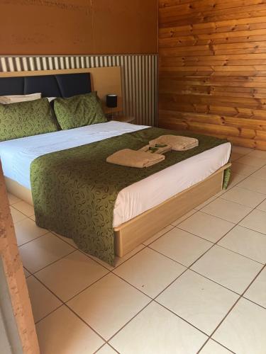 Un dormitorio con una cama y una pared de madera. en Territory Manor Motel & Caravan Park, en Mataranka