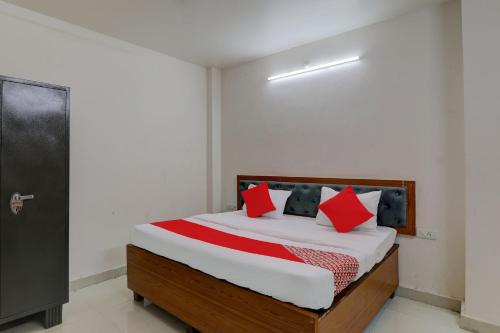 a bedroom with a bed with red pillows at FabHotel Raas Inn in Lucknow