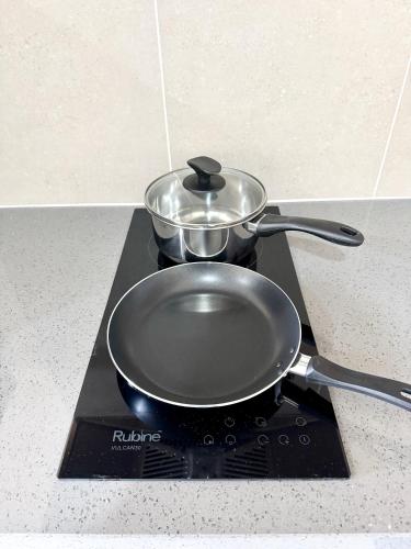 a pan on a stove with two pans on it at Alinea Suites by Moka in Shah Alam