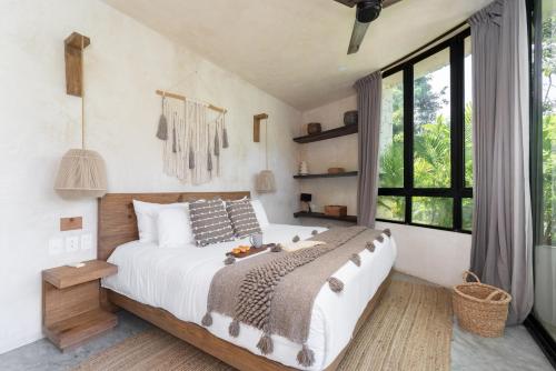 a bedroom with a large bed and a large window at 2 Tropical Bohemian Villas-2 Priv Pool-BBQ 3A-3B in Tulum