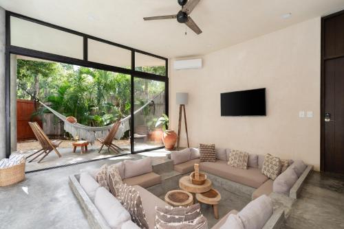 a living room with a couch and a tv at 2 Tropical Bohemian Villas-2 Priv Pool-BBQ 3A-3B in Tulum