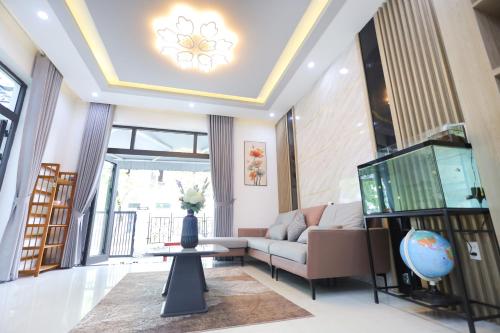 a living room with a couch and a tv at KenPi House in Hue