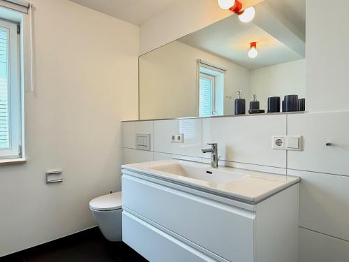 a white bathroom with a sink and a toilet at Ferienhaus 's Sommerhäusle - gemütlich und modern mit Garten in Lindau in Lindau
