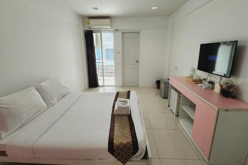 a bedroom with a large bed and a flat screen tv at Zenith Life Hotel in Ban Bang Khen (1)
