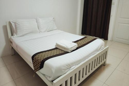 a white bed with two towels on top of it at Zenith Life Hotel in Ban Bang Khen (1)