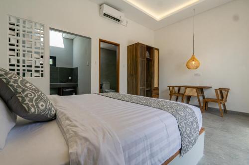 a bedroom with a large bed and a table at Kardi Residence By Bali Cabin in Cemagi