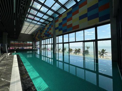 a swimming pool with a view of the beach and the ocean at Flamingo Hai Tien in Nam Khê