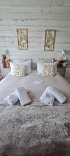 Elle comprend un grand lit blanc avec des oreillers et des serviettes. dans l'établissement Le Cocon de Mina, 15 min du Puy du Fou, à Mortagne-sur-Sèvre