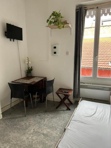 une pièce avec une table, des chaises et un lit dans l'établissement O métro gratte-ciel, à Villeurbanne