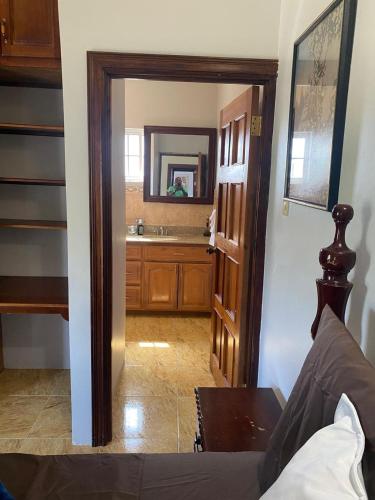 a room with a bathroom with a sink and a mirror at Sukasa Ville in Montego Bay