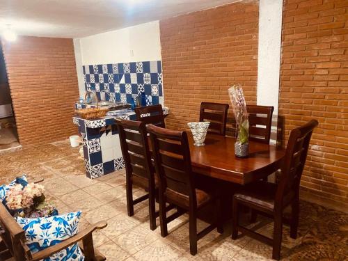 a dining room with a wooden table and chairs at Cabaña rodeada de naturaleza in Pátzcuaro