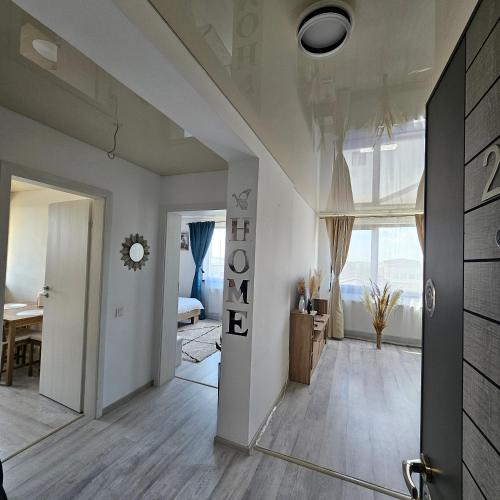 a living room with white walls and a large window at Cozy SoRaDa 3 apartment in Bragadiru
