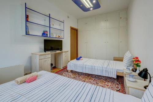 a hotel room with two beds and a television at Steady - Guests Rooms in Varna City
