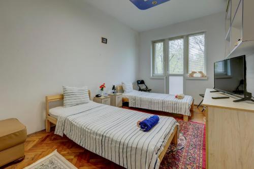 a room with two beds and a television in it at Steady - Guests Rooms in Varna City