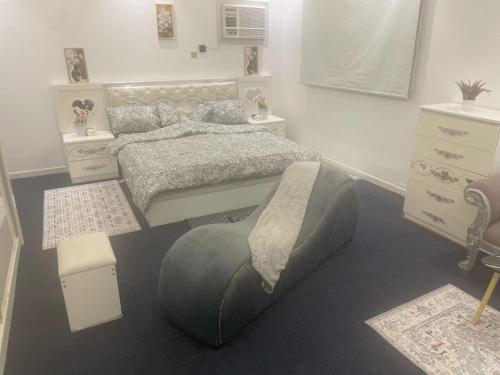 a bedroom with a bed and a ottoman in it at منازل سارا 3 Sara Houses in Tabuk