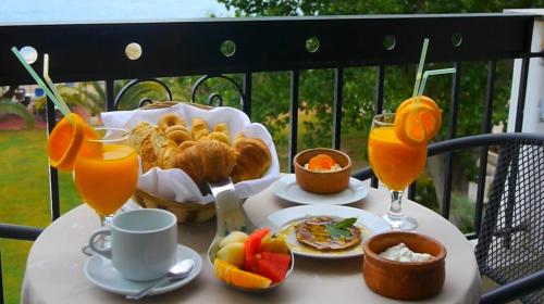a table with food and two glasses of orange juice at Apollon Hotel in Ancient Epidavros