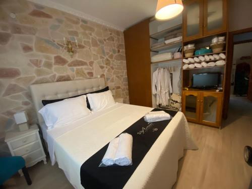 a bedroom with a bed and a stone wall at Hermione's house in Vrontados