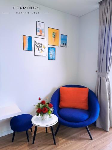 a blue chair with an orange pillow and a table at Flamingo Hai Tien in Nam Khê