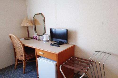 a desk with a computer on it with a mirror at 東洋白浜リゾートホテル in Kannoura
