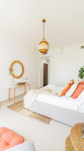 a white bedroom with a bed and a mirror at Voyage One Bedroom In Arc Tower Reem Island in Abu Dhabi