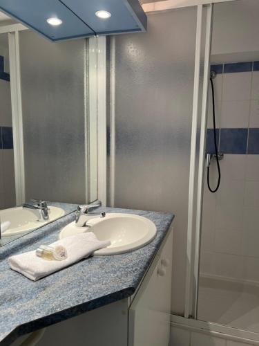 une salle de bain avec un lavabo, un miroir et une douche dans l'établissement Appartement 7 personnes base de loisirs des Bouldouires, à La Salvetat-sur-Agout
