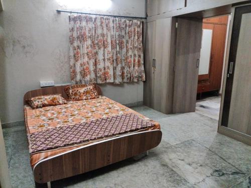 a bedroom with a bed in a room with a curtain at Metropolitan Retreat in Bengaluru
