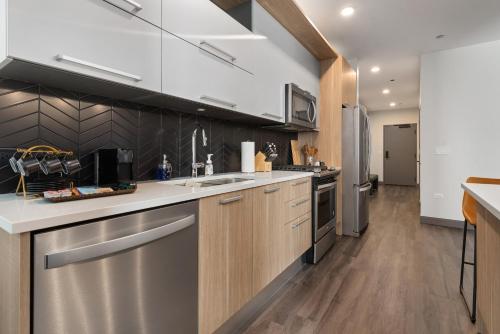 a kitchen with stainless steel appliances and wooden cabinets at Experience Downtown Chicago at Millennium - Luxury Apartments in The Loop in Chicago