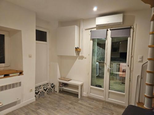 Cette chambre dispose d'une porte en verre et d'une fenêtre. dans l'établissement maison de village meublée avec terrasse, à Donzère