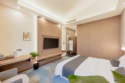a hotel room with a bed and a television at 华泱温泉酒店-青城山店 in Taiping