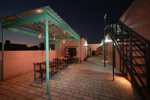 a patio with tables and chairs at night at Ardas Villa Bikaner - Heritage Luxury Boutique Stay in Bikaner