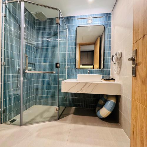a bathroom with a shower and a sink and a mirror at Flamingo Hai Tien in Hoằng Hóa