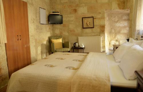 a bedroom with a bed and a tv on the wall at Urgup Konak Hotel in Urgup