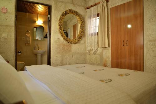 a bedroom with a bed and a mirror and a sink at Urgup Konak Hotel in Urgup