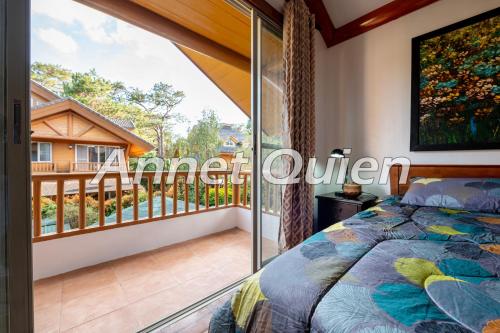 a bedroom with a balcony with a bed at Camp John Hay 4BR Cabin in Baguio