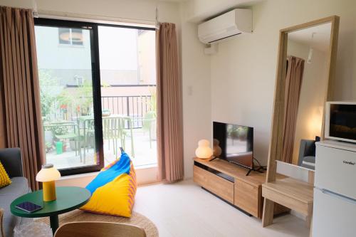 a living room with a large window and a television at Mi-HOTEL ATELIER SHINJUKU in Tokyo