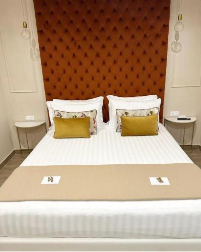 a bedroom with a large bed with yellow pillows at Nouvelle Maison Rome Luxury Palace in Rome