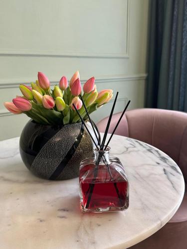 a vase with flowers in it on a table at Nouvelle Maison Rome Luxury Palace in Rome