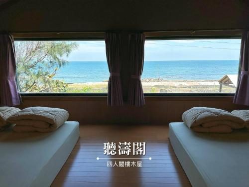a room with two beds and a view of the ocean at 澎湖民宿-旺旺部落 in Magong