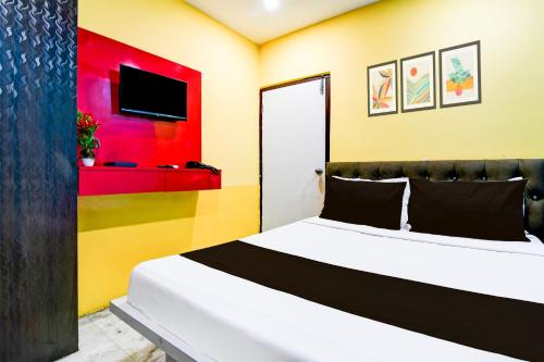 a bedroom with a white bed and a colorful wall at Super Hotel O Kolkata Near Acropolis Mall Formerly 7 Horse GH in Kolkata