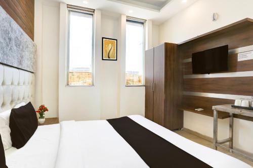 a bedroom with a bed and a tv on a wall at Super Hotel O Chandigarh Highway Near Prabhat Road in Zirakpur