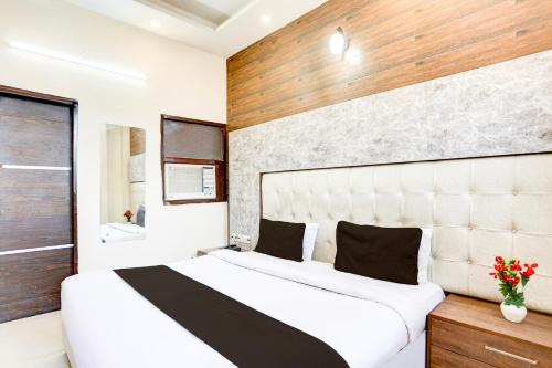 a bedroom with a large white bed and a window at Super Hotel O Chandigarh Highway Near Prabhat Road in Zirakpur