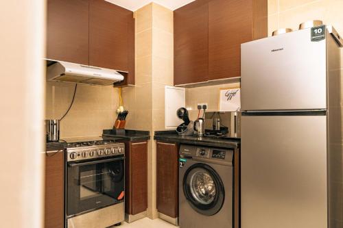 a kitchen with a refrigerator and a washing machine at Voyage Two Bedroom In Reem Island in Abu Dhabi
