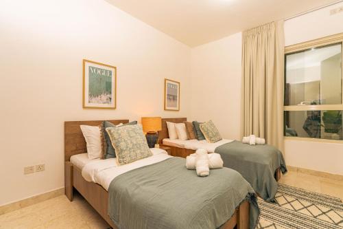 a bedroom with two beds and a window at Voyage Two Bedroom In Reem Island in Abu Dhabi