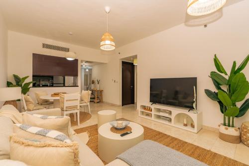 a living room with a couch and a flat screen tv at Voyage Two Bedroom In Reem Island in Abu Dhabi