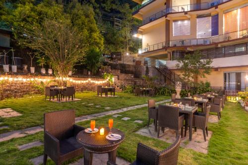 a restaurant with tables and chairs in a yard at night at Karnika Resort Levelup Boutique-Dharamshala in Dharmsala