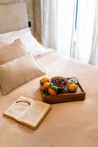 a tray of fruit and a book on a bed at Shanti Dubrovnik in Dubrovnik