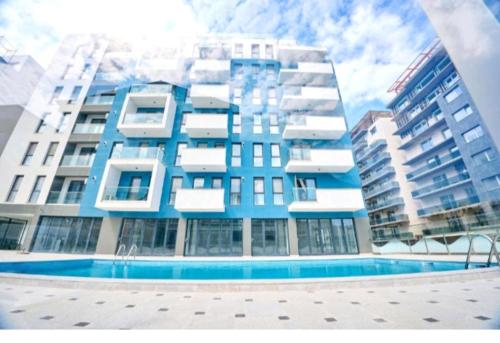 ein großes Gebäude mit einem Pool davor in der Unterkunft COZY studiou Mamaia Nord by Alezzi in Mamaia Nord – Năvodari