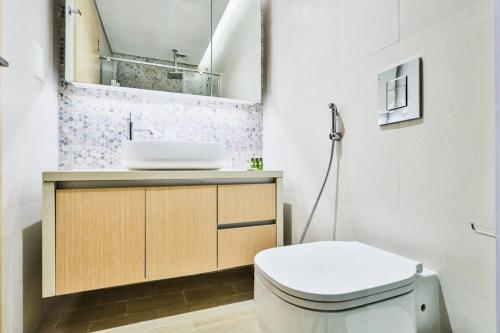 a bathroom with a white toilet and a sink at Voyage Studio In Mayan in Abu Dhabi