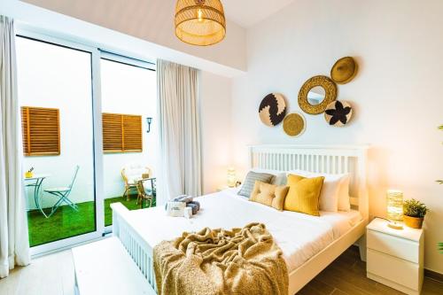 a bedroom with a bed and a large window at Voyage Studio In Mayan in Abu Dhabi